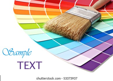 Paintbrush and colorful paint samples on white background with copy space.