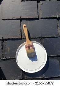 Paintbrush Resting On Paint Bucket Lid On A Roof