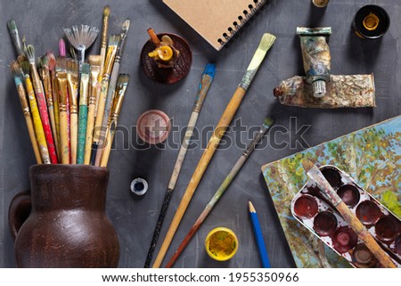 Paintbrush and tubes with painter tools at abstract table background texture. Art painter concept and paint brush