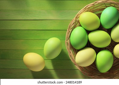 Painted Easter Eggs Basket On Wooden Background/ Top View