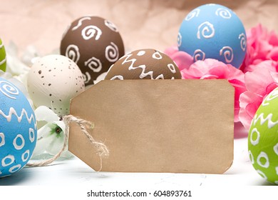Painted easter eggs and branches of spring sakura closeup on a light blue background with space for congratulation