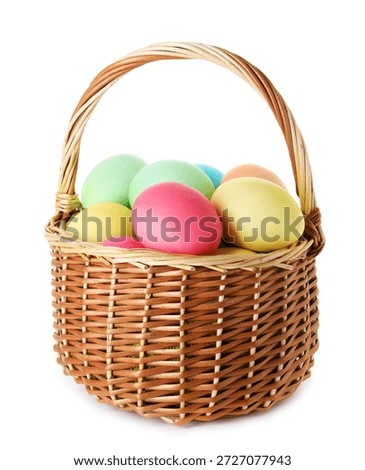 Painted Easter eggs in wicker basket isolated on white