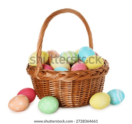 Painted Easter eggs in wicker basket isolated on white