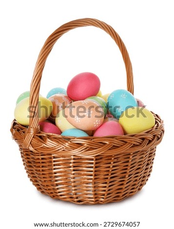 Painted Easter eggs in wicker basket isolated on white