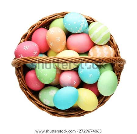 Painted Easter eggs in wicker basket isolated on white, top view