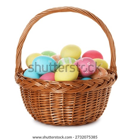 Painted Easter eggs in wicker basket isolated on white