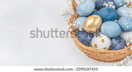 painted eggs for Easter in basket with flowers on light background. Happy easter concept. copy space.