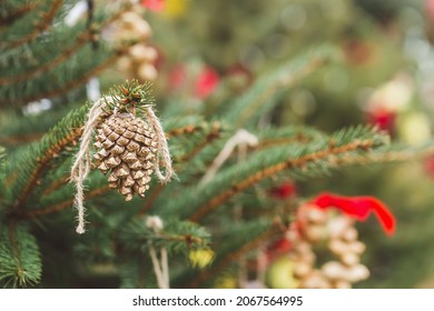 Painted Gold Pine Cone On Christmas Tree. Diy Decoration Ideas For Children. Environment, Reuse, Recycle, Upcycling And Zero Waste Concept. Selective Focus, Outdoor No Snow Background