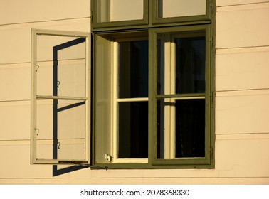 painted green wood window. beige stucco elevation. old classic architecture. decorative facade. buildings and archiecture concept. travel and tourism. urban detail in Europe. bright light with shadows