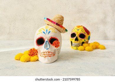 Painted human skulls for Mexico's Day of the Dead (El Dia de Muertos) and flowers on light background