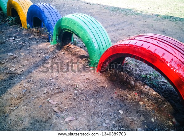 Painted old car tires, Old colored\
tires buried in the soil And painted old tires for\
beauty.