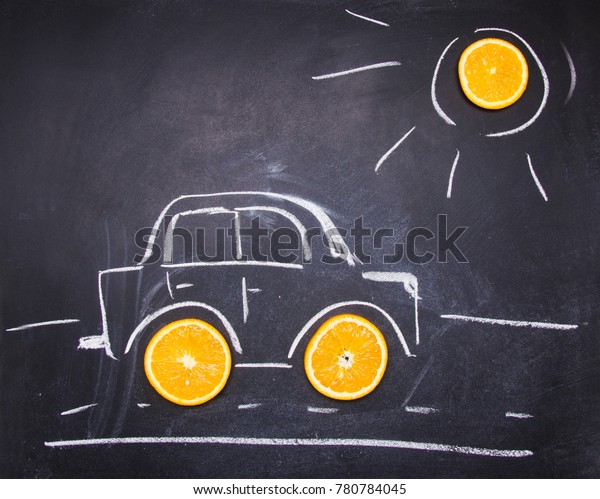 painted on a chalkboard a car with orange slices\
instead of wheels