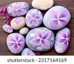 Painted round natural stones with decorative flowers.