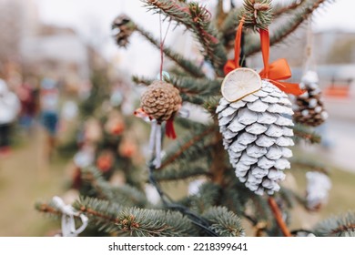 Painted White Pine Cone And Dried Lemon On Christmas Tree. Diy Decoration Ideas For Children. Environment, Reuse, Recycle, Upcycling And Zero Waste Concept. Selective Focus, Outdoor No Snow Background