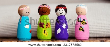 Painted wooden peg dolls of different races; small wooden dolls painted by a child
