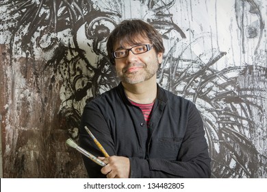 Painter Artist With Black Glasses Posing In Front Of His Mural Paint