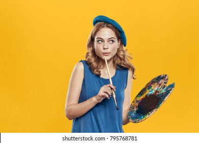 Painter In A Beret With A Brush On A Yellow Background                              