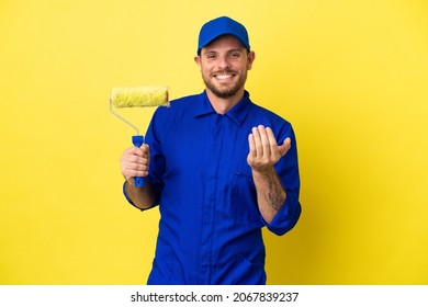 Painter Brazilian man isolated on yellow background inviting to come with hand. Happy that you came