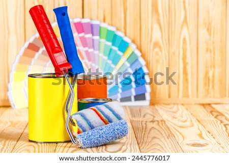 Painter and decorator work table with house project, color swatches, painting roller and paint brushes