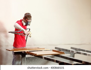 A Painter Finishing Cabinet Doors With A Clear Lacquer Spray At A Cabinet Shop.