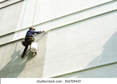 Painter Hanging On White Building