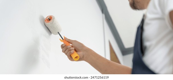 painter man, brush in hand for products to restore and paint the wall, indoor the building site of a house, wall during painting, renovation, painting, contractor, Architect, construction worker - Powered by Shutterstock