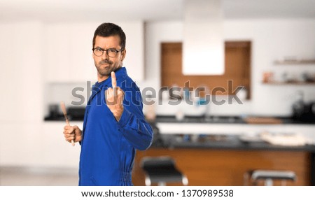 Painter man making horn gesture at home