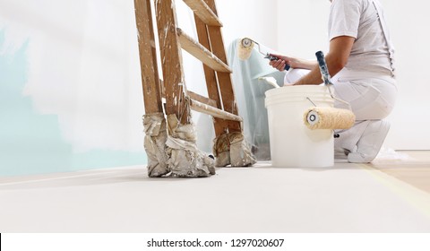 Maler auf der Arbeit mit einer Walze, Eimer und Skala von unten, Kopienraum-Vorlage