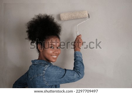 painter man at work with a roller, Portrait of young good-looking African woman with pretty smile.
