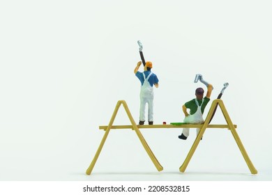 painter on a wooden scaffold at work, isolated on white background