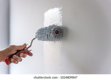 Painter Painting A House Wall With A Paint Roller.