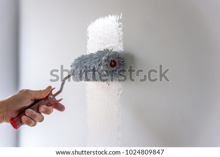 Painter Painting a House Wall with a Paint Roller.