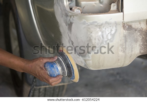 Painter\
polishes a car body component - auto body\
repair
