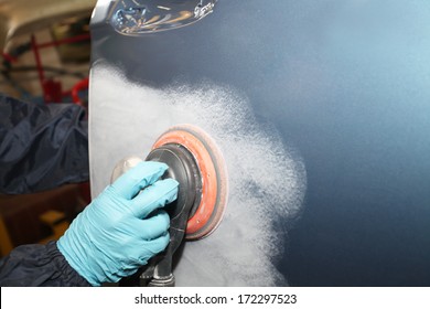 Painter polishs a car body component