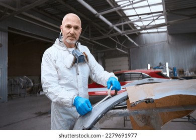 Painter prepares a part of the car body for work - Powered by Shutterstock