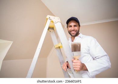 Painter Smiling Standing On Ladder In A New House