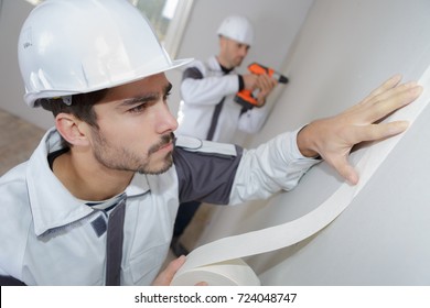 Painter Using Masking Tape Before Painting