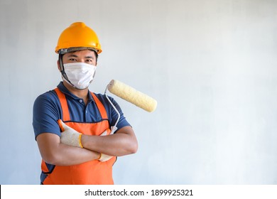 A painter wearing a protective mask Be committed to painting houses and buildings with new house paint rollers.