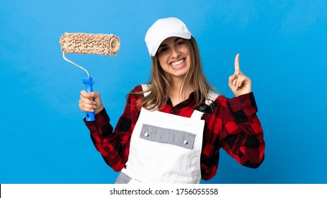 Painter Woman Over Isolated Blue Background Pointing Up A Great Idea