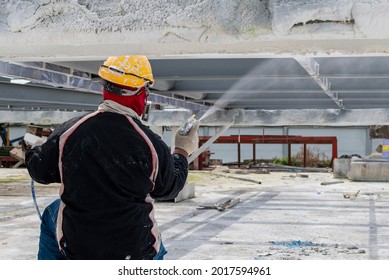 Painter Is Working To Fireproof Paint On Steel Structure With Spray Gun.