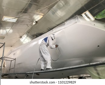 Painters are spraying paint to repair Sailing yacht at shipyard , factory in Phuket,Thailand