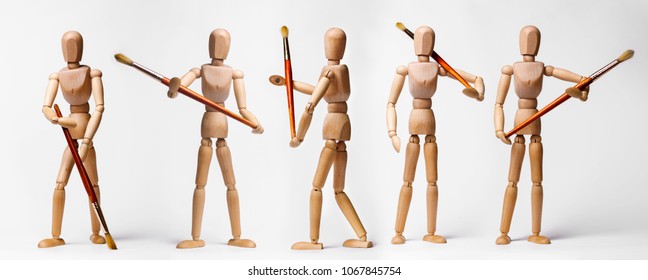 Painter's wooden models holding paintbrushe in different poses isolated on white - Powered by Shutterstock