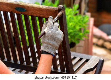 Painting and applying protective varnish on a wooden garden chair