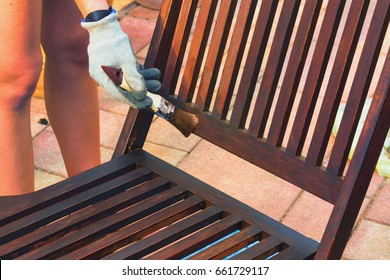 Painting And Applying Protective Varnish On A Wooden Garden Chair