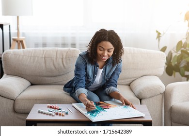 Painting For Beginners. Young black woman drawing picture by numbers with acrylic paints on canvas, enjoying creative leisure activities