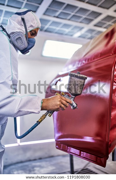 Painting the car door in red color in the\
painting chamber.