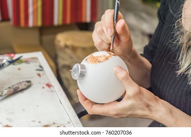 Painting of Christmas decorations, Woman paints with a brush Christmas ball - Powered by Shutterstock