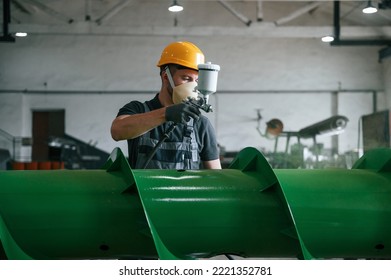 Painting details. Man in uniform is in workstation developing details of agriculture technique. - Powered by Shutterstock