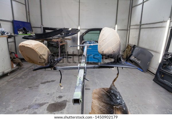 Painting and drying in\
professional box of car body parts after applying putty and paint\
on  black mirrors in the body repair shop with white lanterns in \
workshop