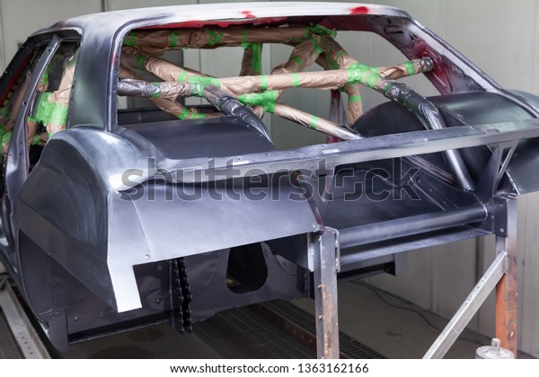 Painting in gray and black color of the outside of\
the frame of the car disassembled after the accident the inside is\
sealed with paper from splash in the workshop for body repair and\
tuning of vehicl